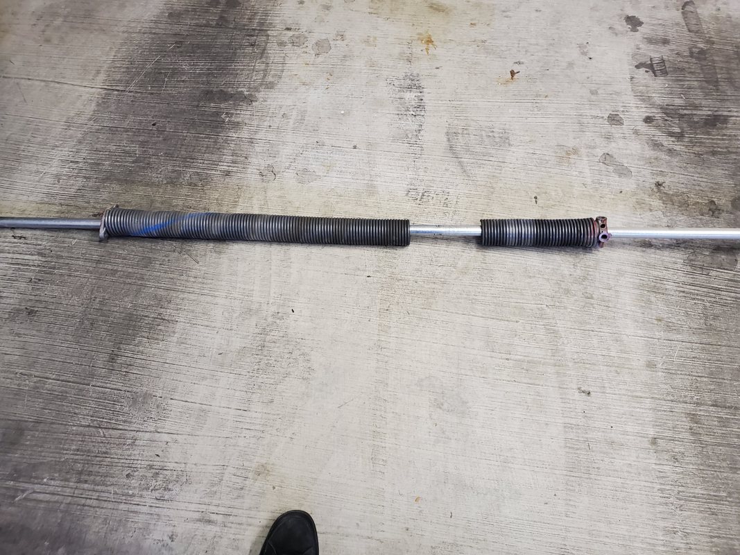 Broken garage door torsion spring needing repair